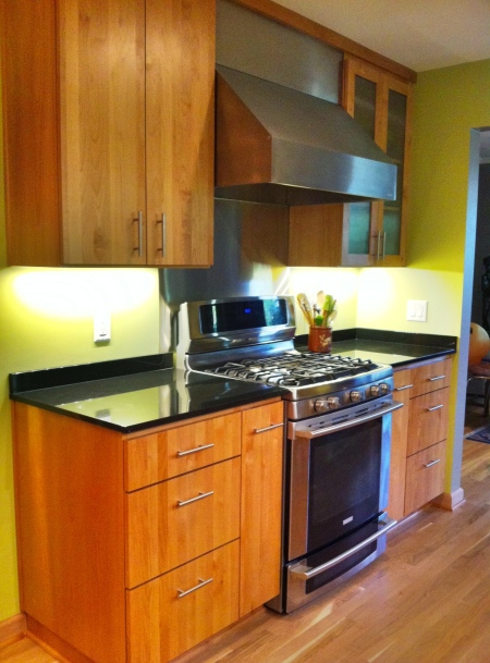 Alder Cabinets compliment the stainless steel range and hood.